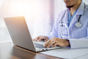 Medical staff entering data into laptop